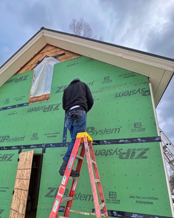 Tony tapes ZIP System panels on east elevation (Photo: R.P. Murphy)