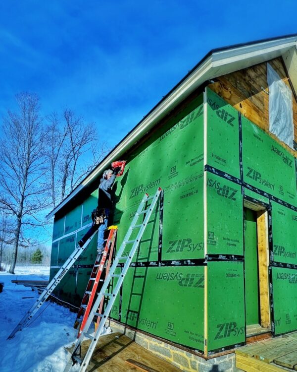 Hroth and Tony installing ZIP System insulated panels on east and west elevations of icehouse (Photo: R.P. Murphy)