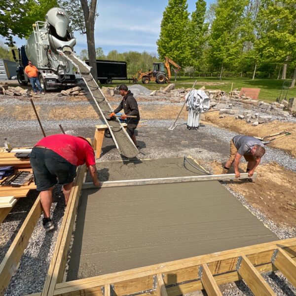 Supi and Calvin Level Hot Tub Slab as Tony Pulls Concrete (Photo: R.P. Murphy)