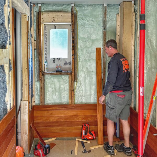 Eric Crowningshield Installing Garapa Paneling in Icehouse Bathroom (Photo: R.P. Murphy)