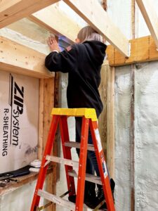 January 2023 Framing Flashback: Pam Installing Hurricane Hangers (Photo: Hroth Ottosen)