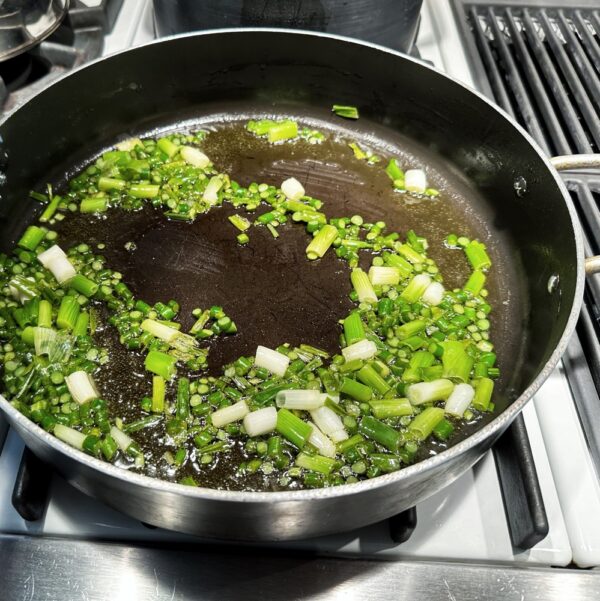 Sautéing Garlic Scapes and Spring Onions​ (Photo: Geo Davis)